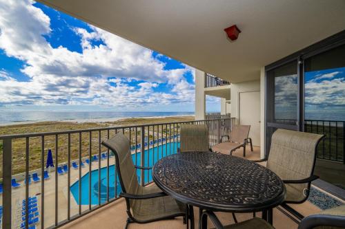 a balcony with a table and chairs and a pool at Phoenix VI 6312 in Orange Beach