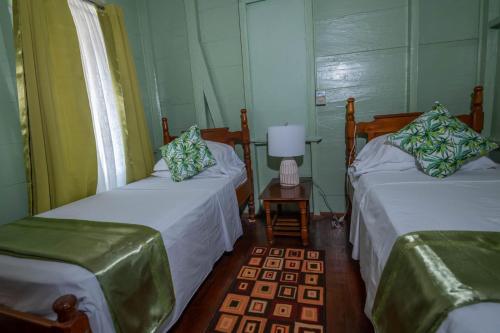 a room with two beds and a table with a lamp at Cholson Chalets in Charlotteville