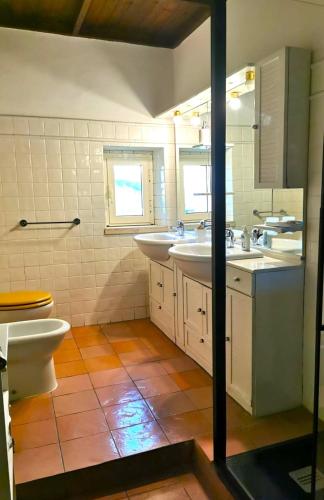 a bathroom with two sinks and a toilet at Villa Dei Romani - Country House in Guidonia