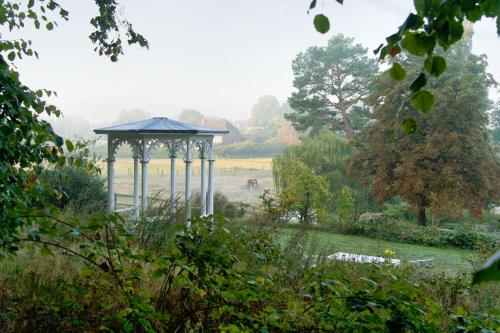 a gazebo in the middle of a garden at Gut Groß Zecher - Ferienzimmer in Seedorf