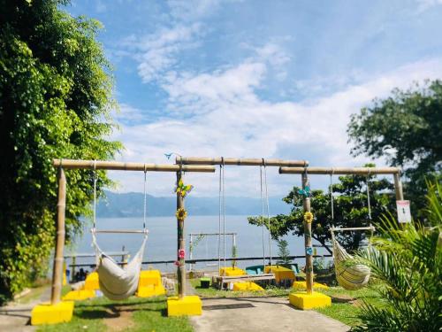 an empty playground with swings and a view of the water at Hotel Porto Bello in San Pedro La Laguna