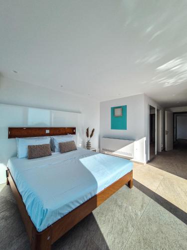a bedroom with a large bed with blue sheets at Villa Símera in Laganas