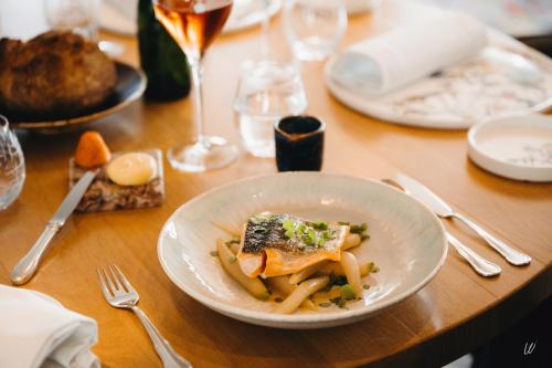 a white plate of pasta on a wooden table at Armes de Champagne in Châlons-en-Champagne