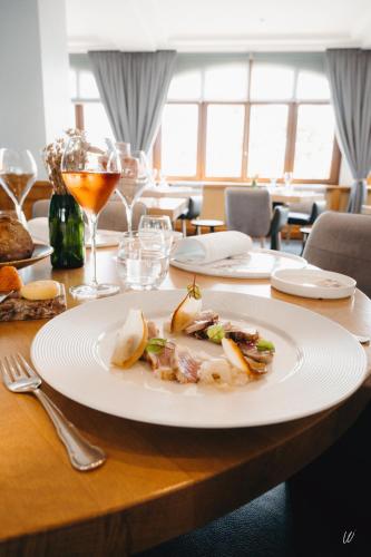 a table with a plate of food and glasses of wine at Armes de Champagne in Châlons-en-Champagne