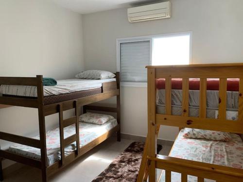 a bedroom with two bunk beds and a window at Triplex em Caraguatatuba! Alto padrão in Caraguatatuba