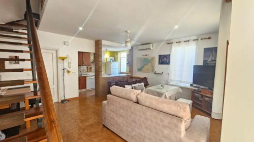 a living room with a couch and a television at El Fortín de la playa by Sanlúcar Housing in Sanlúcar de Barrameda
