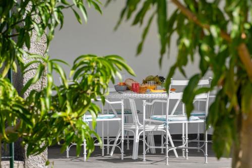 a table with chairs and a table with food on it at Casa do Beiral by An Island Apart in Santa Cruz