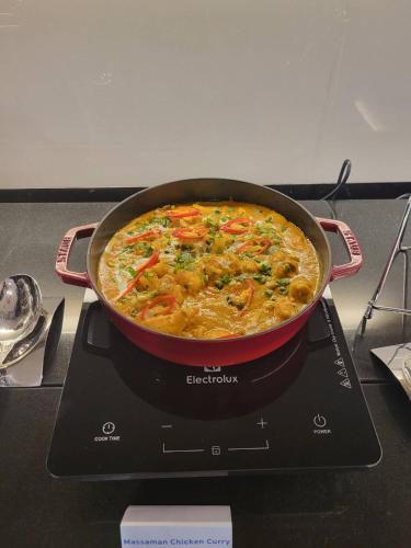 a pan of food sitting on top of a stove at Skye Hotel Bangkok in Bangkok