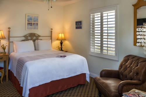 a bedroom with a bed and a chair at The Eagle Inn in Santa Barbara