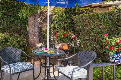 a table with two chairs and an umbrella on a patio at The Eagle Inn in Santa Barbara
