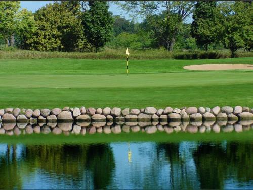 a golf course with a reflection in the water at Woodfalls Luxury Getaway in Bournemouth