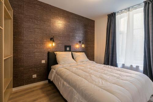 une chambre avec un grand lit et une fenêtre dans l'établissement Charmant appartement au cœur du quartier historique des Allemands, à Metz