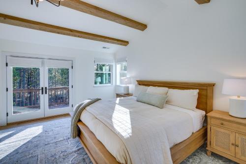 a white bedroom with a large bed and windows at Mountain Home with Private Hot Tub and River Access! in Bend