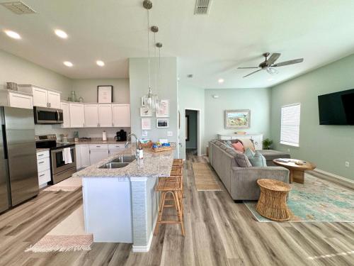Una cocina y una sala de estar con un sofá y una mesa. en Cozy Bay Cottage with King Master Suite, Fire Pit and Pool, en Palm Harbor