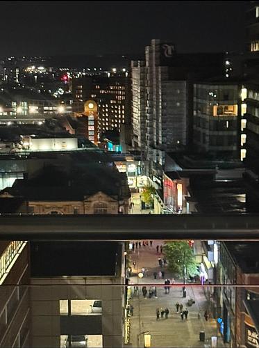 a city at night with people walking on a street at Winners of 2025 traveller Award, Elegant two bedroom city central apartment with Netflix & WiFi in Leeds