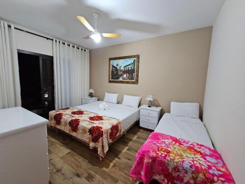 a bedroom with two beds and a ceiling fan at Piemont Flat Apart in Serra Negra