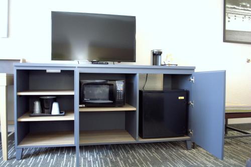 a desk with a tv and a microwave at Country Inn & Suites by Radisson, Port Clinton, OH in Port Clinton