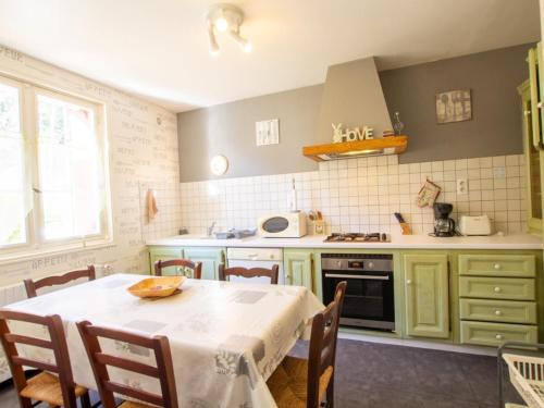 une cuisine avec une table et un chiffon de table blanc dans l'établissement Évasion en Dordogne: Maison au bord de l'eau avec parking privé - FR-1-616-413, à Mauzac-et-Grand-Castang