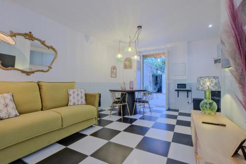 - un salon avec un canapé et un sol en damier dans l'établissement Chez Madeleine au Petit Palais, à Périgueux