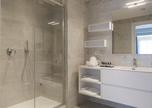 a bathroom with a glass shower and a sink at Maritim Resort Calabria in Villapiana