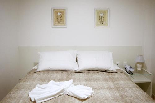 a bedroom with a bed with white towels on it at Pousada Lorde Inglês in Recife