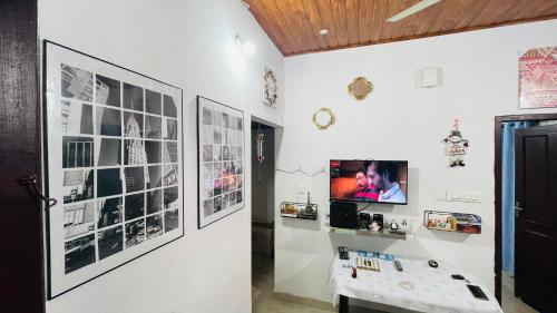 a room with pictures on the wall and a tv at Munnar Hills And Mist Views in Anachal