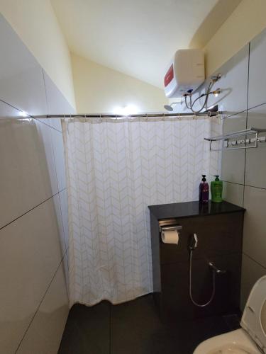 a bathroom with a shower curtain and a toilet at The Forest Temple in Kaniyāmbetta