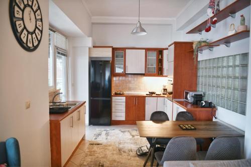 a kitchen with a table and a clock on the wall at Maison du Lac in Kastoria