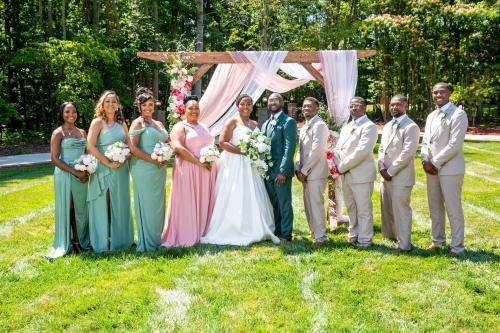 a group of people standing in front of a wedding arch at Whisper Chateau Weddings Reunions Groups 75 Plus in Greensboro