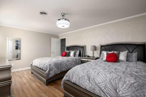 a bedroom with two beds with red pillows at Whisper Chateau Weddings Reunions Groups 75 Plus in Greensboro