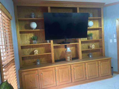 a large wooden entertainment center with a flat screen tv on it at Whisper Chateau Weddings Reunions Groups 75 Plus in Greensboro