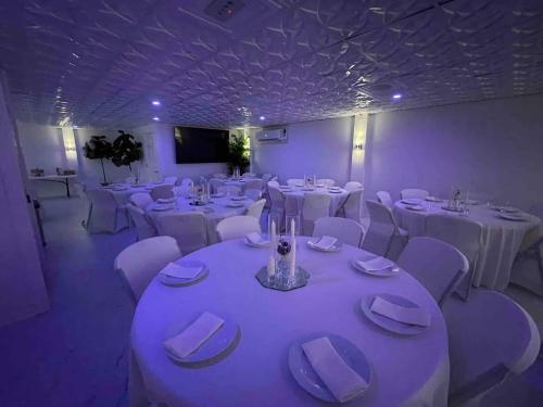 a large room with white tables and white chairs at Whisper Chateau Weddings Reunions Groups 75 Plus in Greensboro