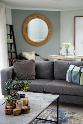 a living room with a couch and a table with plants at Beachfront Villa Sea Breeze Hout Bay Cape Town in Hout Bay