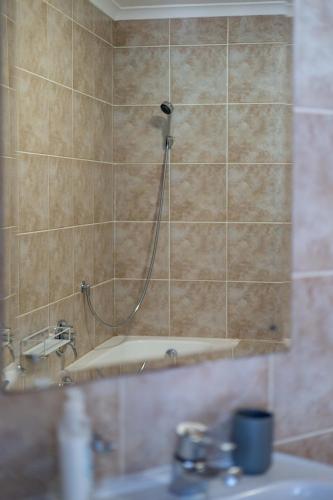 a bathroom with a shower with a sink and a mirror at Beachfront Villa Sea Breeze Hout Bay Cape Town in Hout Bay
