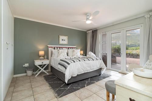 a bedroom with a large bed and a window at Beachfront Villa Sea Breeze Hout Bay Cape Town in Hout Bay