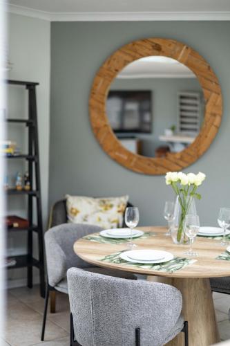 a dining room with a table with a mirror at Beachfront Villa Sea Breeze Hout Bay Cape Town in Hout Bay