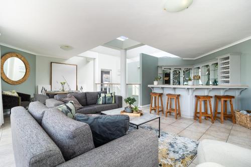 a living room with a couch and a bar at Beachfront Villa Sea Breeze Hout Bay Cape Town in Hout Bay
