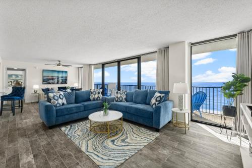 a living room with a blue couch and a table at Sandpiper Beacon Beach Resort in Panama City Beach