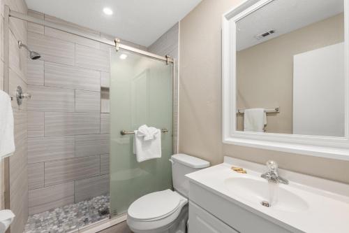 a bathroom with a toilet and a sink and a shower at Sandpiper Beacon Beach Resort in Panama City Beach