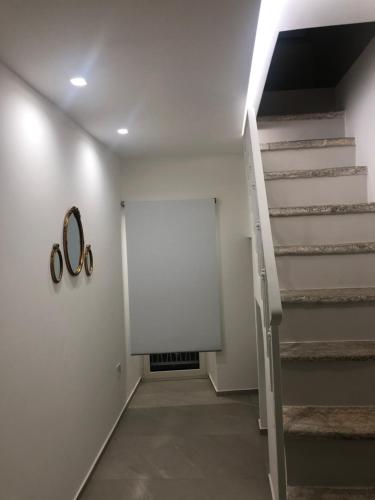 a hallway with stairs and two pairs of scissors on the wall at Netium B&B in Andria