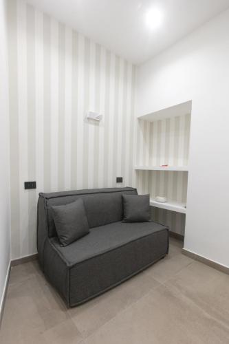 a couch sitting in a room with striped walls at Pignasecca Domus in Naples