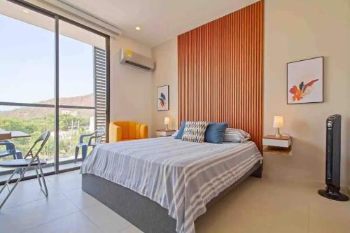 a bedroom with a bed and a large window at Amazing 2BR Apartament with pool in Santa Marta in Santa Marta
