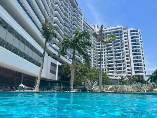 einem Pool mit Palmen vor einem Gebäude in der Unterkunft Majestic 3BR with Fantastic Pool in Bolivar in Gaira