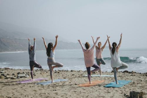 a group of women doing yoga on the beach at Aourir Waves Surf House in Aourir