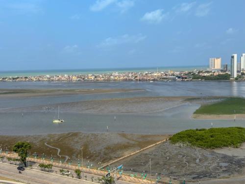 Blick auf einen Fluss mit einem Boot im Wasser in der Unterkunft Apartamento em Recife, condomínio de luxo in Recife