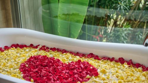 a casserole dish filled with yellow and red flowers at RIMBA by AYANA Bali in Jimbaran