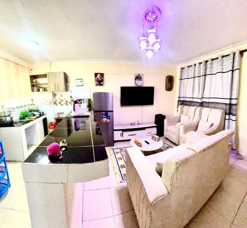 a living room with a couch and a tv at Riverside apartment in Nairobi