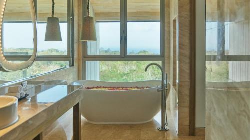 a bath tub in a bathroom with a window at RIMBA by AYANA Bali in Jimbaran