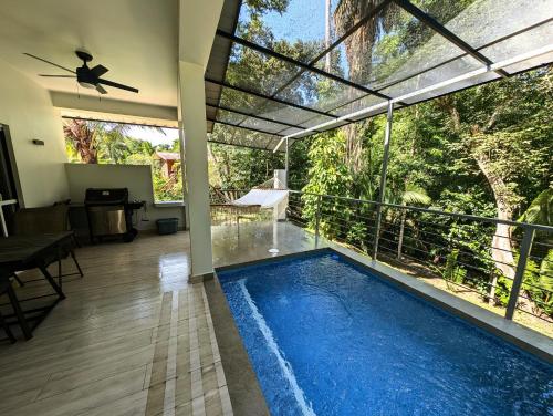 an indoor pool with a view of a house at The Twins Pool Villas in Cristo Rey