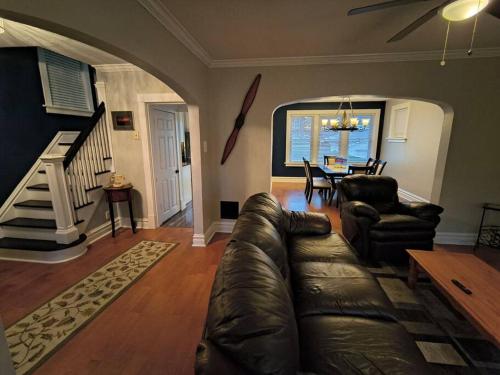 a living room with a leather couch and a table at 2 story nice home with character in Saint Louis